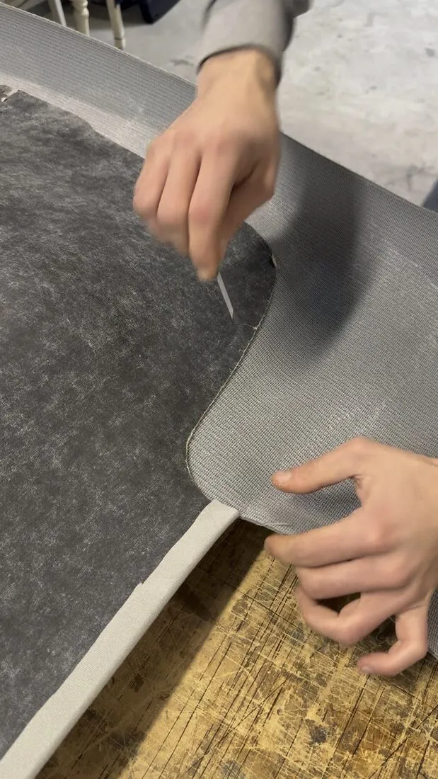 Dépose du vieux tissu de ciel de toit sur la coque d’une Volkswagen Golf 4, posée à plat sur l’établi