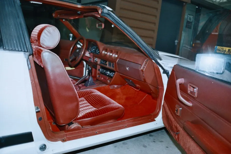 Habitacle rouge de la Datsun 280 ZX, portière ouverte, avec sa moquette neuve posée