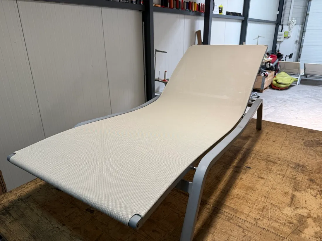 Transat au cadre en aluminium équipé d’une toile Batyline neuve, posé sur l’établi de l’atelier